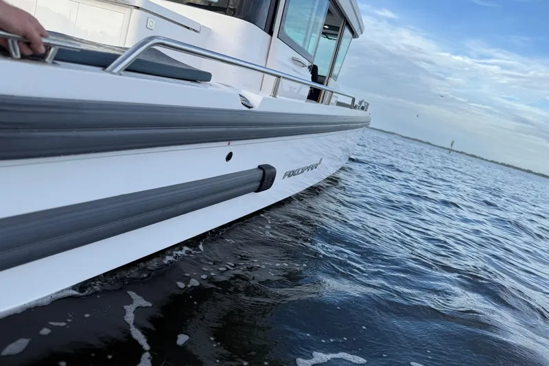 Slide: The Image of 2022 Axopar 28 Cabin boat cruising on open water under a clear sky. - 10