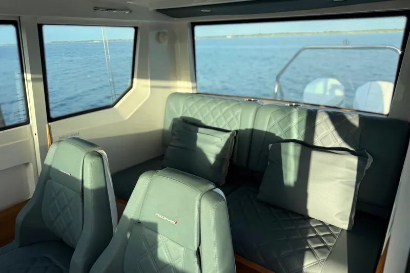 Slide: The Image of Interior of 2022 Axopar 28 Cabin with plush seating and ocean view. - 12