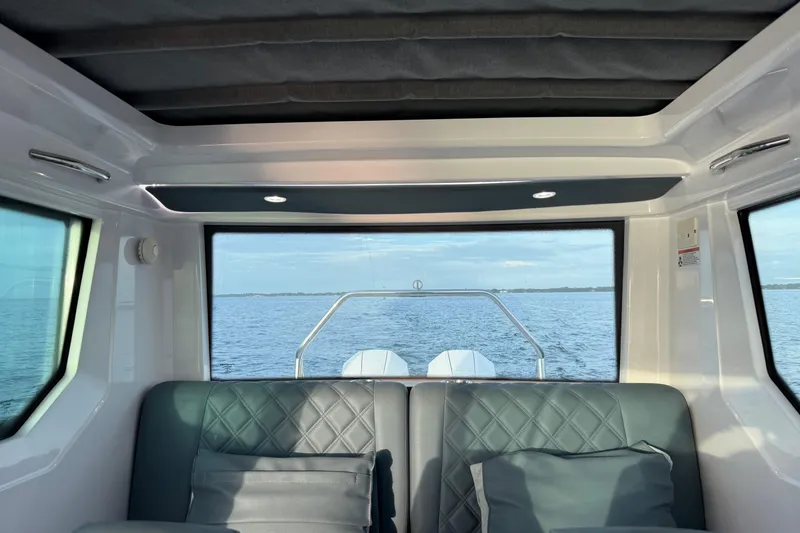 Slide: The Image of Interior view of 2022 Axopar 28 Cabin boat with ocean backdrop. - 20