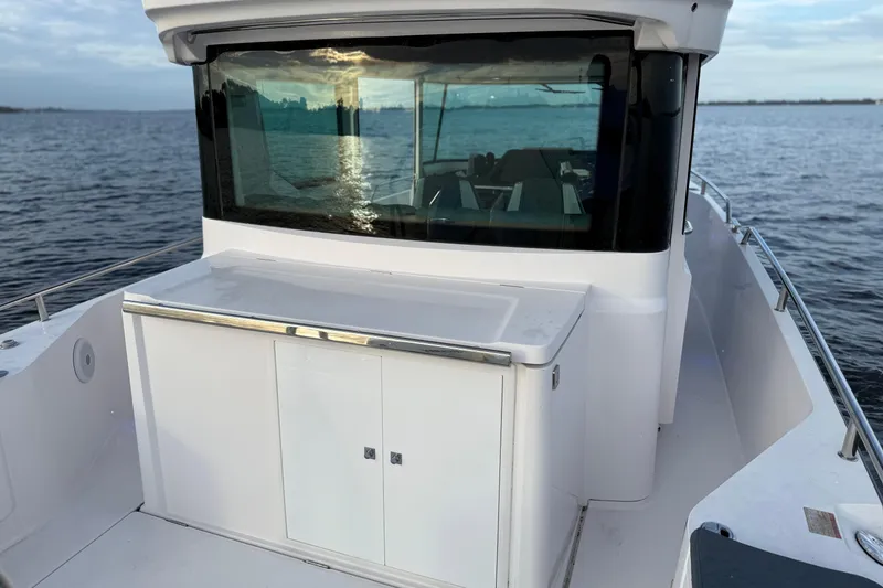 Slide: The Image of 2022 Axopar 28 Cabin boat on calm water, showcasing sleek design and modern cabin. - 9