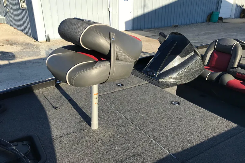 Slide: The Image of 2018 Ranger RT178 boat interior with gray and red seating, parked outdoors. - 10