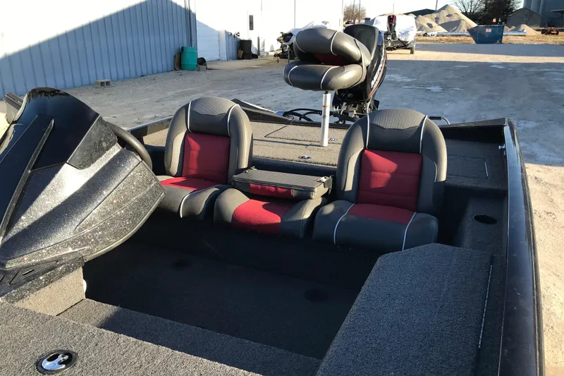 Slide: The Image of 2018 Ranger RT178 boat interior with red and gray seating, parked outdoors. - 11