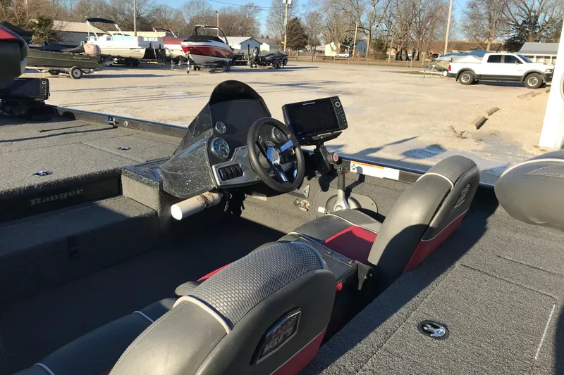 Slide: The Image of 2018 Ranger RT178 boat interior with steering wheel and dashboard in a parking lot. - 12