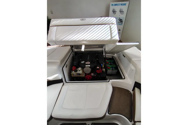 Slide: The Image of 2016 Cobalt 220 boat engine compartment with open hatch, showcasing engine and battery. - 12
