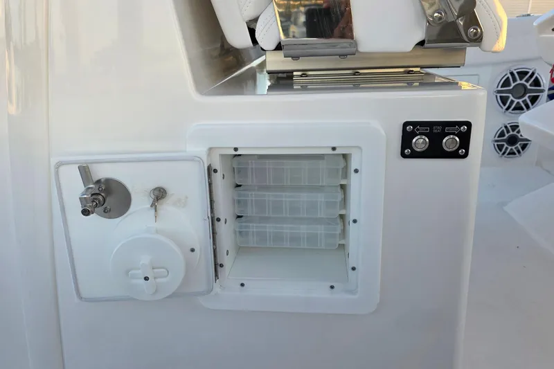 Slide: The Image of 2026 Caymas 34 CT boat storage compartment with control panel and seating mechanism. - 19