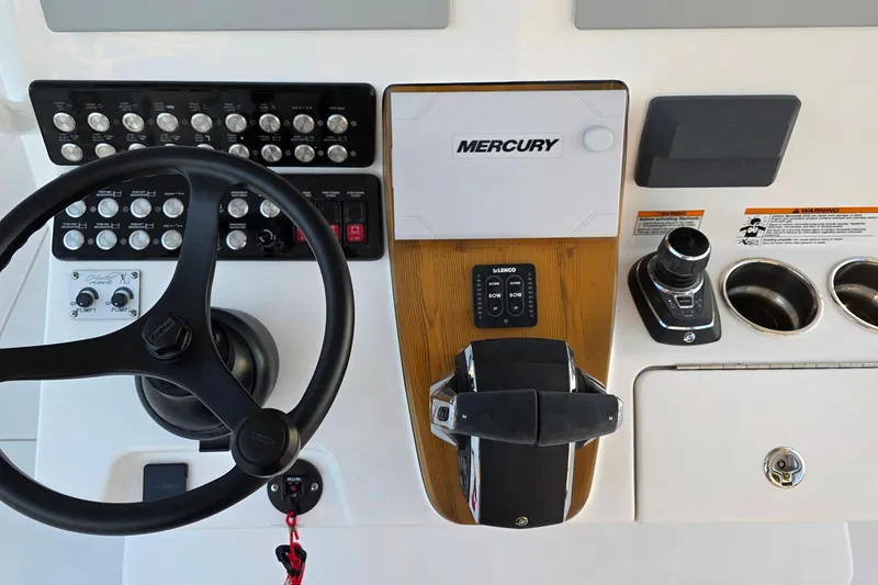Slide: The Image of Control panel of 2026 Caymas 34 CT boat with Mercury throttle and steering wheel. - 21