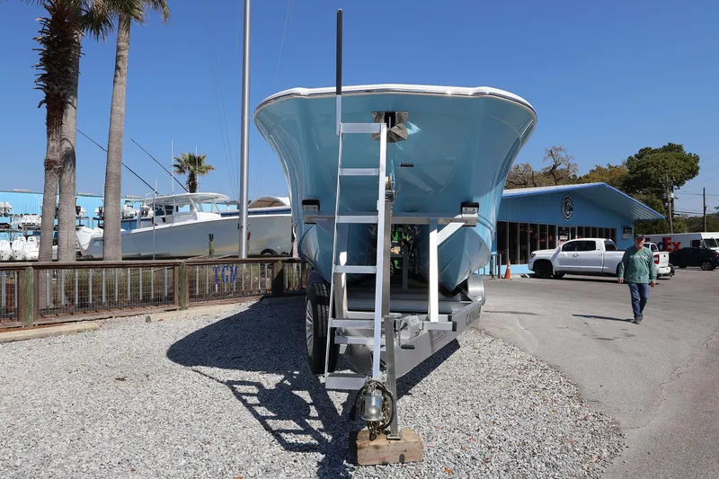 Slide: The Image of 2026 Caymas 34 CT boat on trailer, parked near a blue building under clear sky. - 31
