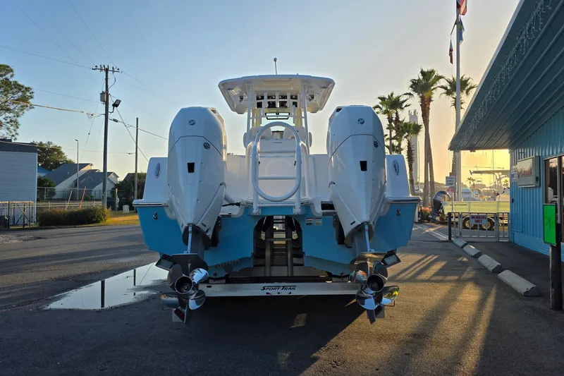 Slide: The Image of 2026 Caymas 34 CT boat with dual engines, parked on a trailer at sunset. - 7