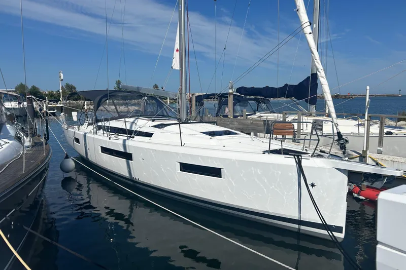 The Image of 2026 Jeanneau 440 Sun Odyssey sailboat docked in a marina under clear blue skies. - 0