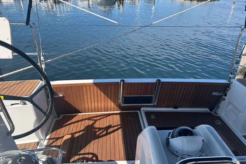 Slide: The Image of 2026 Jeanneau 440 Sun Odyssey cockpit with wooden deck, steering wheel, and marina view. - 4