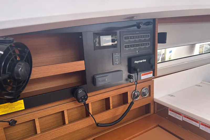 Slide: The Image of 2026 Jeanneau 440 Sun Odyssey interior control panel with navigation equipment and wood finish. - 7