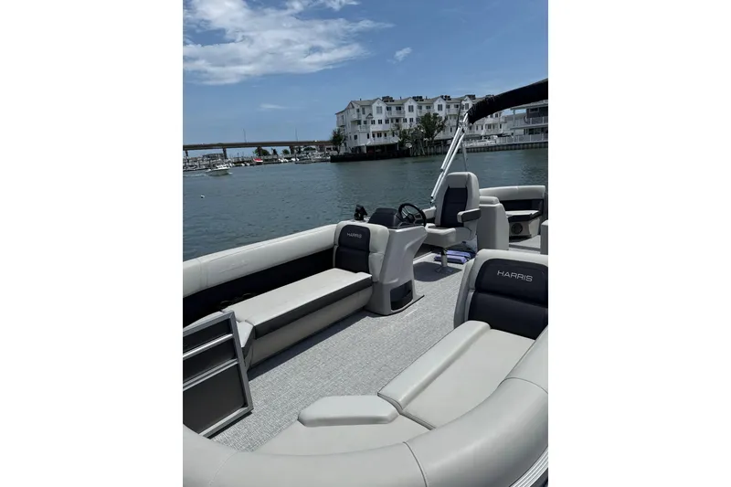 Slide: The Image of 2025 Harris Cruiser 230 pontoon boat interior on a sunny day by the water. - 3