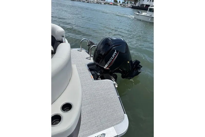 Slide: The Image of 2025 Harris Cruiser 230 pontoon boat with Mercury outboard motor on water. - 9