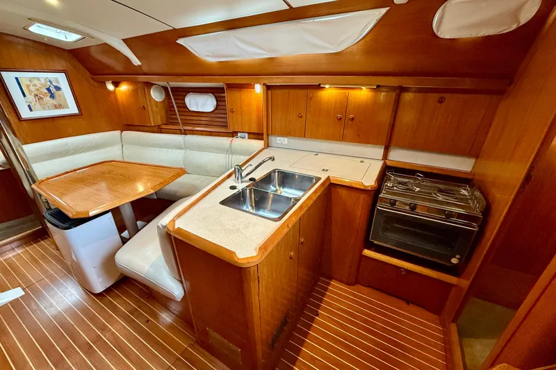 Slide: The Image of Interior of 1997 Jeanneau Sun Odyssey 36.2 sailboat with wood finish and seating area. - 11