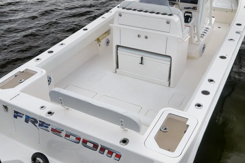 Slide: The Image of 2023 SeaVee 322Z boat deck with storage and seating, on calm water. - 12