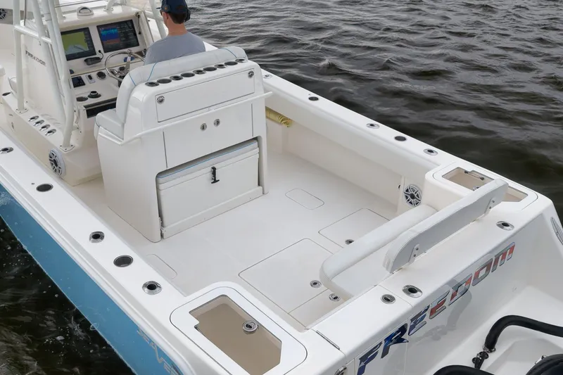 Slide: The Image of 2023 SeaVee 322Z boat interior with helm, seating, and storage, on water. - 13