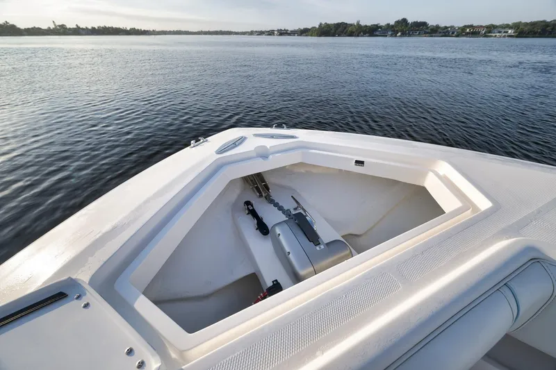 Slide: The Image of 2023 SeaVee 322Z boat bow with anchor compartment on calm water. - 16