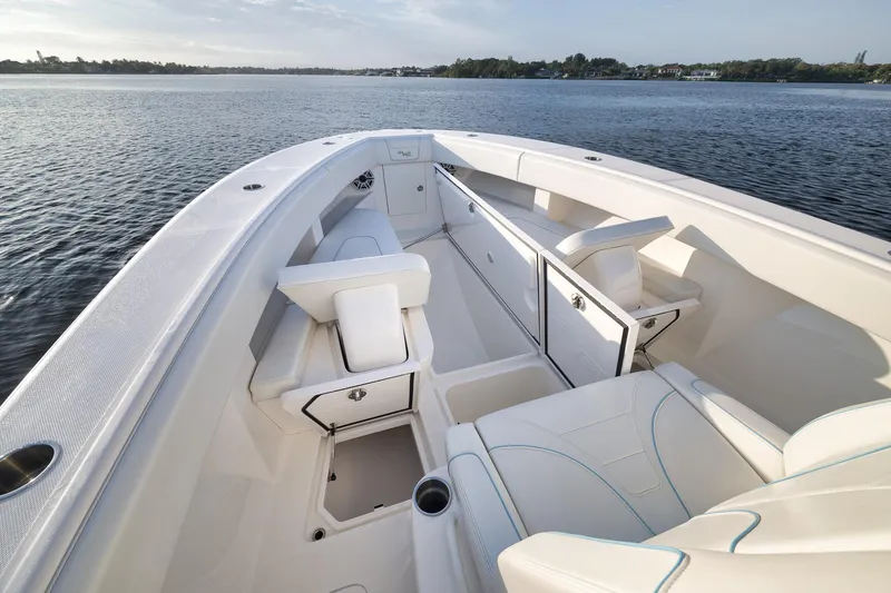 Slide: The Image of 2023 SeaVee 322Z boat interior with white seating and storage compartments on calm water. - 20