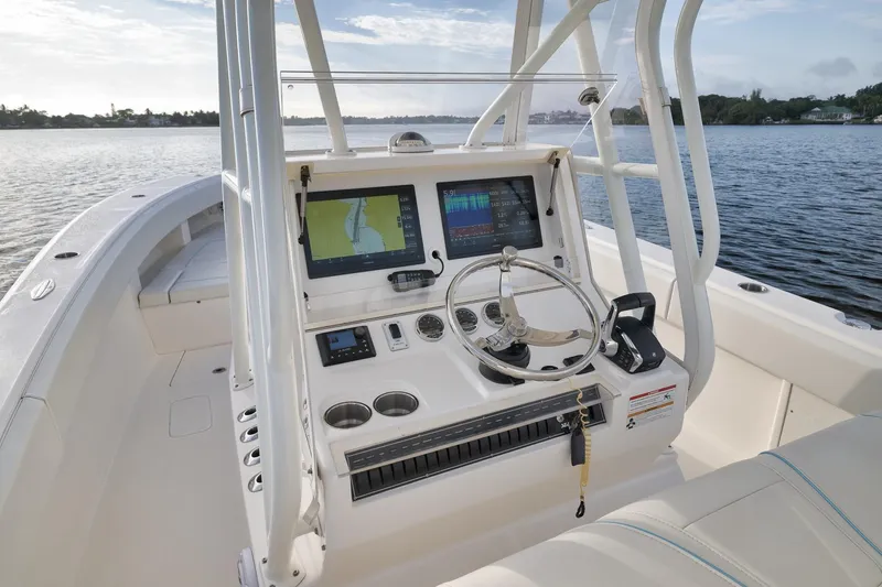 Slide: The Image of 2023 SeaVee 322Z boat console with navigation screens and steering wheel on calm water. - 30