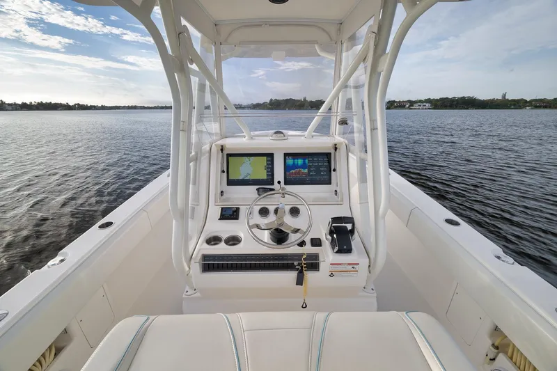 Slide: The Image of 2023 SeaVee 322Z boat helm with navigation screens on calm water. - 32
