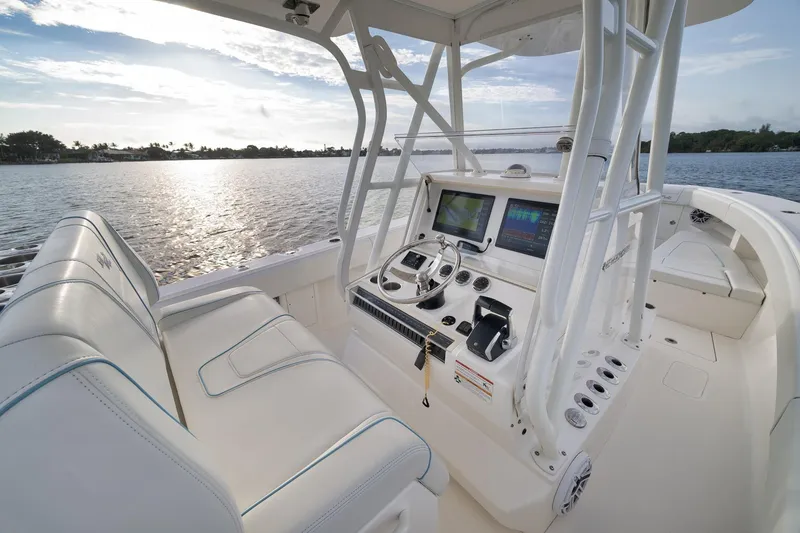 Slide: The Image of 2023 SeaVee 322Z boat cockpit with modern controls and seating, overlooking serene water. - 35