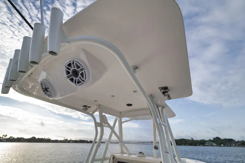 Slide: The Image of 2023 SeaVee 322Z boat with rod holders and speakers under a clear sky. - 36
