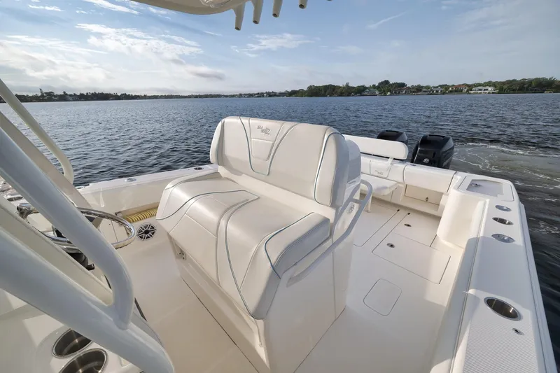 Slide: The Image of 2023 SeaVee 322Z boat interior with white seating, on a calm lake. - 38