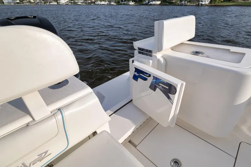 Slide: The Image of 2023 SeaVee 322Z boat interior with seating and storage, on a calm water backdrop. - 42