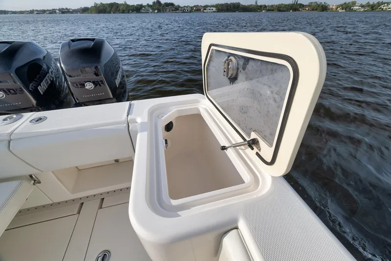 Slide: The Image of 2023 SeaVee 322Z boat with open storage compartment and twin Mercury engines on water. - 43