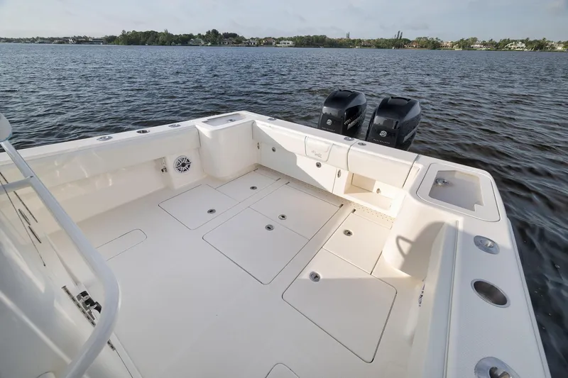 Slide: The Image of 2023 SeaVee 322Z boat deck with dual engines on calm water. - 45