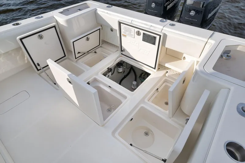 Slide: The Image of 2023 SeaVee 322Z boat deck with open storage compartments and dual engines. - 47