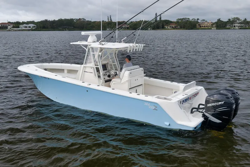 Slide: The Image of 2023 SeaVee 322Z boat on water with dual Mercury engines, light blue hull. - 5