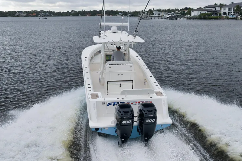 Slide: The Image of 2023 SeaVee 322Z boat cruising on a calm waterway, rear view. - 53