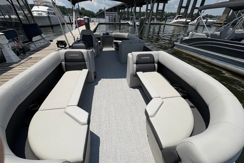 Slide: The Image of 2025 Harris Cruiser 230 pontoon boat interior with spacious seating at marina. - 4