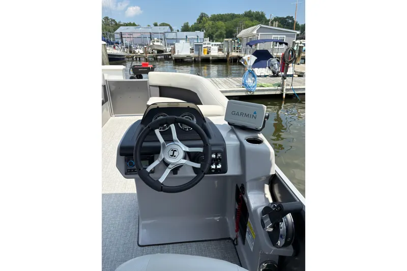 Slide: The Image of 2025 Harris Cruiser 230 boat helm with Garmin navigation at marina. - 6