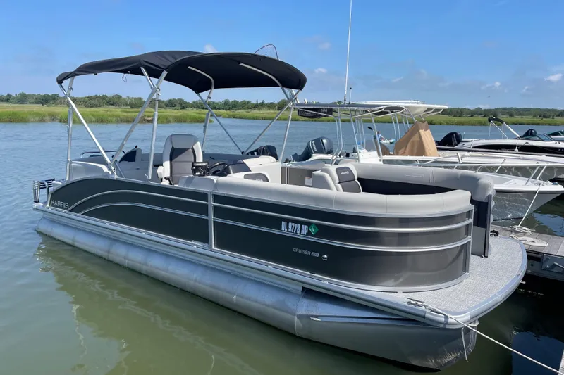 The Image of 2025 Harris Cruiser 230 pontoon boat docked on a sunny day. - 1