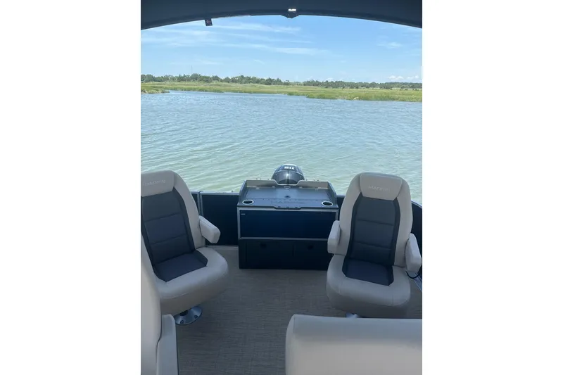 Slide: The Image of Interior view of 2025 Harris Cruiser 230 boat with two seats overlooking water. - 10