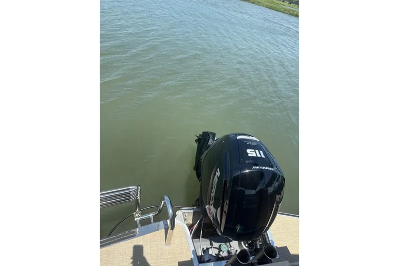 Slide: The Image of 2025 Harris Cruiser 230 with Mercury 115 outboard motor on calm water. - 11