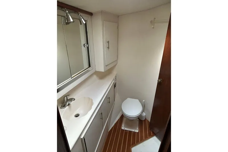 Slide: The Image of Bathroom interior of 1988 Ocean Yachts 48 Super Sport with sink, toilet, and wood flooring. - 11