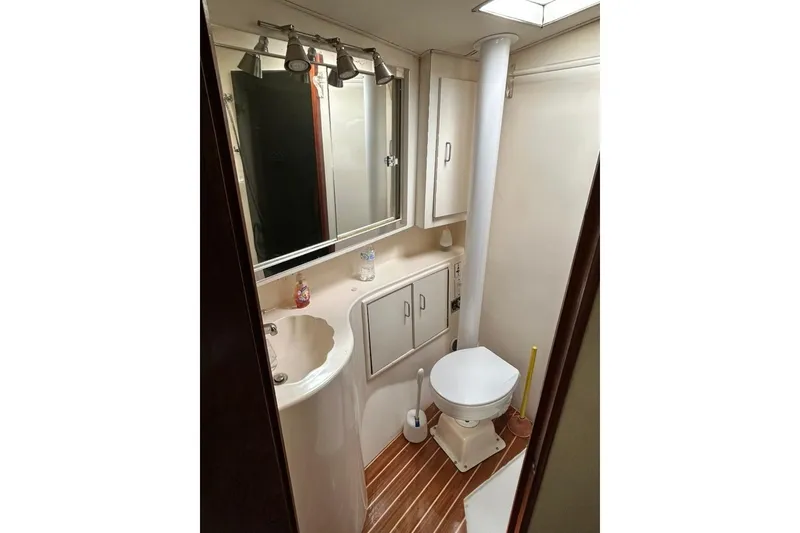 Slide: The Image of Bathroom interior of 1988 Ocean Yachts 48 Super Sport, featuring sink, toilet, and mirror. - 13