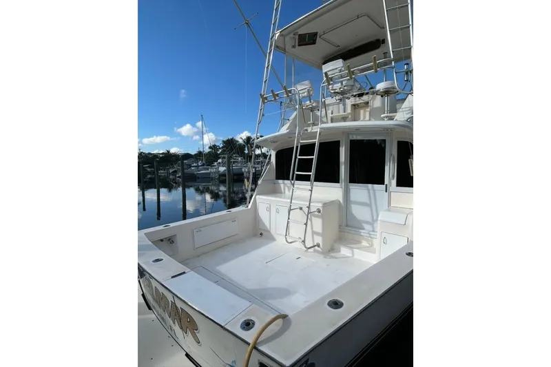 Slide: The Image of 1988 Ocean Yachts 48 Super Sport docked, featuring spacious deck and ladder. - 2