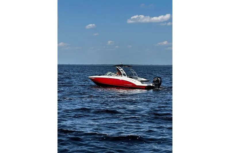 Slide: The Image of 2023 Chaparral 23 SSi OB boat on open water under blue sky. - 3
