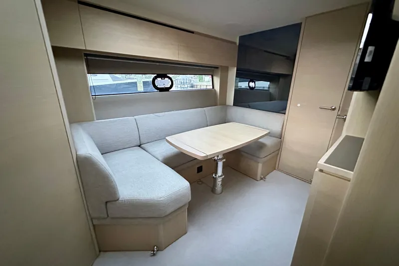 Slide: The Image of Luxurious 2021 Princess V40 yacht interior with elegant seating and wooden table, overlooking serene waters. - 2