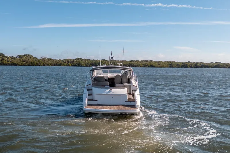 Slide: The Image of 2021 Princess V40 yacht cruising on a serene lake under a clear blue sky. - 52