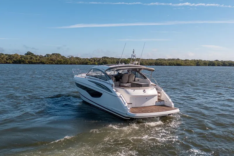 Slide: The Image of 2021 Princess V40 yacht cruising on a serene lake under a clear blue sky. - 53