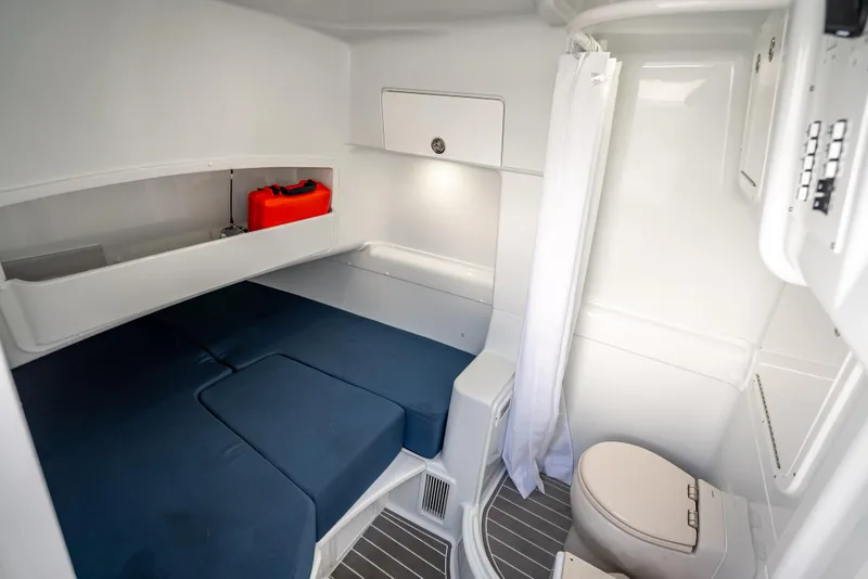 Slide: The Image of 2025 Yellowfin 42 Offshore cabin interior with bed, storage, and marine toilet. - 12