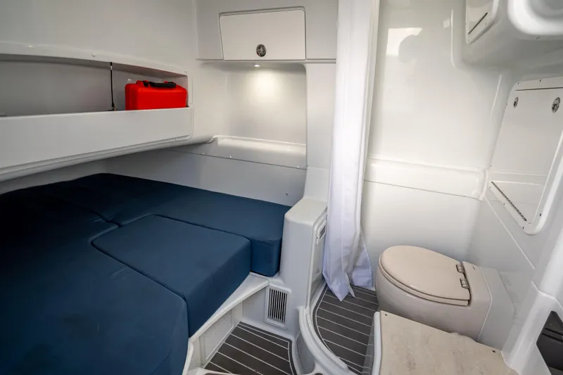 Slide: The Image of 2025 Yellowfin 42 Offshore cabin interior with bed and compact bathroom. - 13