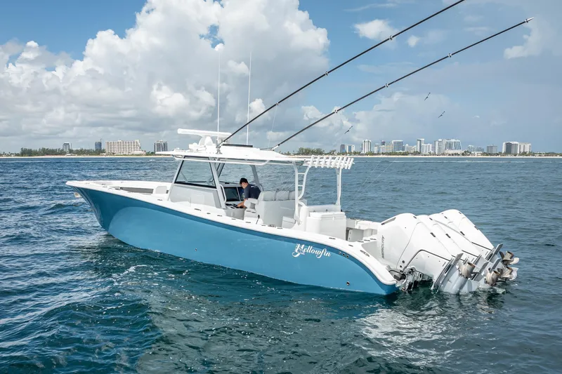 Slide: The Image of 2025 Yellowfin 42 Offshore boat on open water, city skyline in background. - 3