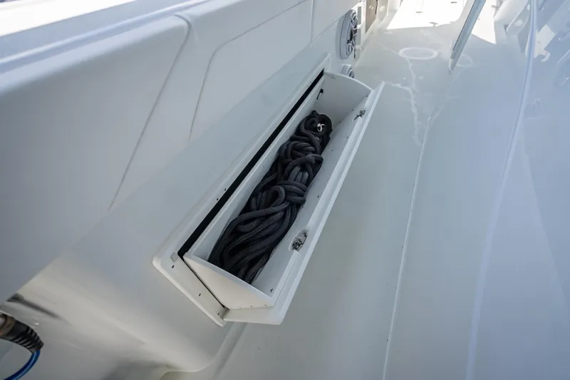 Slide: The Image of 2025 Yellowfin 42 Offshore boat storage compartment with coiled rope. - 32