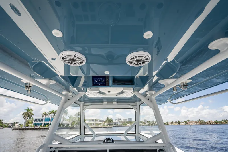 Slide: The Image of 2025 Yellowfin 42 Offshore boat interior with blue ceiling and speakers, cruising on a sunny day. - 38